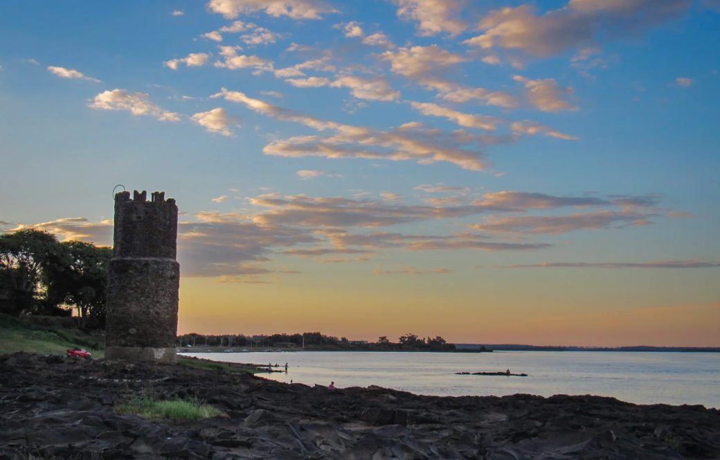 Torre y piedras en la costa de Monte Caseros al atardecer
